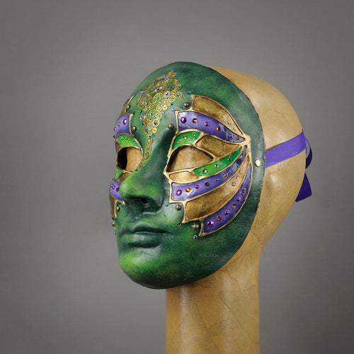 Green Steampunk Droid Mask. This unique piece is hand painted in shades of green and accented in purple and gold. Details include Swarovski Crystals, metal findings and assorted watch gears.  Handmade in the USA using the traditional Venetian paper mache process. Lined with soft stretch velvet for comfort. Side view.