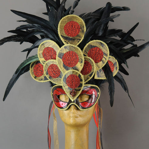 Become a Goddess at your next masquerade party in this stunning Red, black and gold Fire Sylph Masquerade Mask! This is an avant-garde piece with a crest of hand made paper panels in a peacock motif laying over pitch black coque feathers. Embellished with Swarovski crystals, and polished stones.  Handmade in the USA using traditional Venetian paper-mache technique. Lined with hypoallergenic stretch velvet for comfort. Detail view.