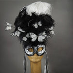 Beautiful Masquerade Mask, crested in Black and White Ostrich Plumes and assorted plumage. White feather monarch butterflies flutter on the crest. Embellished with Swarovski crystals, dichroic glass and polished black quartz.  Hand made in the USA using traditional Venetian paper-mache technique. Lined with hypoallergenic stretch velvet for comfort.
