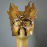 The Copper Warrior Bauta Masquerade mask is Inspired by medieval armor of the Renaissance. With it's masculine lines, this mask is particularly popular for men and is a lightweight and comfortable mask that is perfect for Halloween and Masquerade events. Mask is treated in shades of gold and copper with Dragon Wing panel armor, metal findings and assorted polished gems.  Handmade in the USA using traditional Venetian paper-mache techniques. Lined with hypoallergenic stretch velvet for comfort.