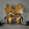 The Copper Warrior Bauta Masquerade mask is Inspired by medieval armor of the Renaissance. With it's masculine lines, this mask is particularly popular for men and is a lightweight and comfortable mask that is perfect for Halloween and Masquerade events. Mask is treated in shades of gold and copper with Dragon Wing panel armor, metal findings and assorted polished gems.  Handmade in the USA using traditional Venetian paper-mache techniques. Lined with hypoallergenic stretch velvet for comfort. Detail view.