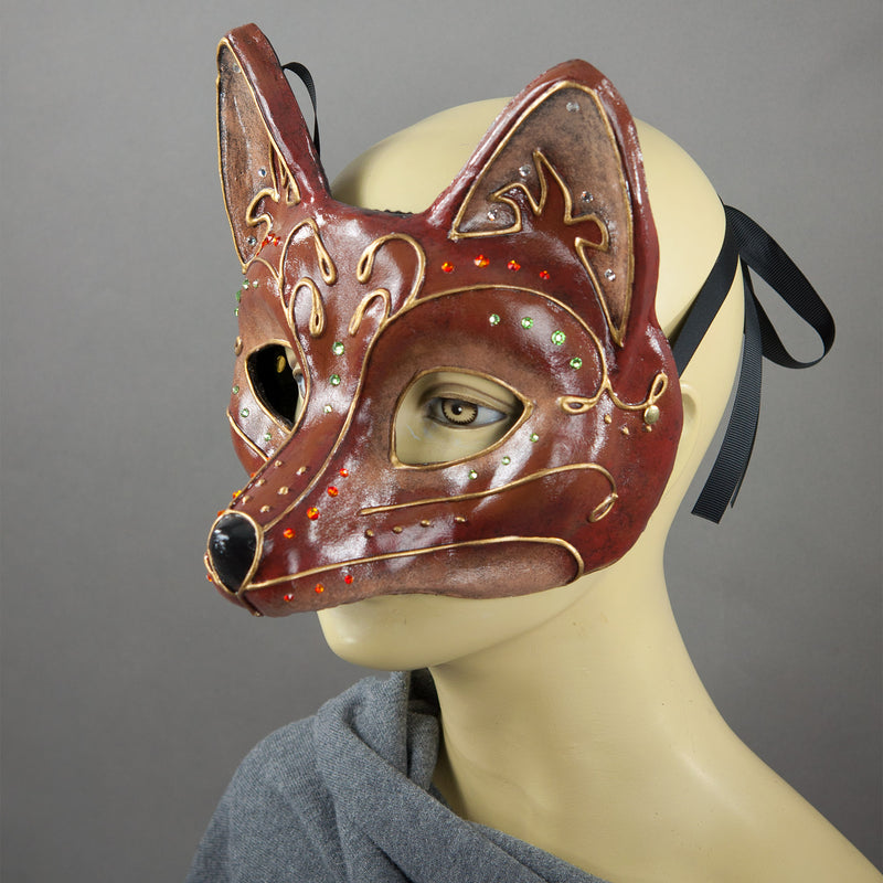 Fancy Red Fox Masquerade Mask. A lightweight comfortable mask inspired by the sly red fox, decorated with an elegant gold scroll motif and embellished with Swarovski Crystals and assorted gems.  Hand Made in the USA using traditional Venetian paper-mache techniques and lined with soft stretch velvet for comfort. Side view.