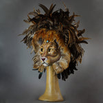 Stunning Lion Mask with a luxe crest of natural coque and assorted pheasant plumage. Embellished with Swarovski crystals, and assorted polished gem stones. Sure to turn heads at any costume, masquerade or Halloween party!  Hand-made in the USA using traditional Venetian paper-mache technique. Lined with hypoallergenic stretch velvet for comfort. Side view.
