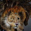 Stunning Lion Mask with a luxe crest of natural coque and assorted pheasant plumage. Embellished with Swarovski crystals, and assorted polished gem stones. Sure to turn heads at any costume, masquerade or Halloween party!  Hand-made in the USA using traditional Venetian paper-mache technique. Lined with hypoallergenic stretch velvet for comfort. Detail side view.
