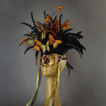 Beautiful Masquerade Mask, in shades of black and Metallic copper.Crested with black coque feathers and assorted dyed plumage. Orange and gold feather Monarch butterflies flutter on the crest. Embellished with Swarovski crystals, seashells and polished stones.  Hand made in the USA using traditional Venetian paper-mache technique. Lined with hypoallergenic stretch velvet for comfort. Side view.