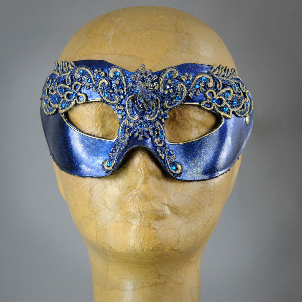 Simple, elegant eye mask in Metallic Sapphire Blue and Black with gold accents. Embellished with lacquered lace, glass gems, Swarovski crystals and polished stones.  Hand made in the USA using traditional Venetian paper-mache techniques. Lined in stretch velvet for comfort.