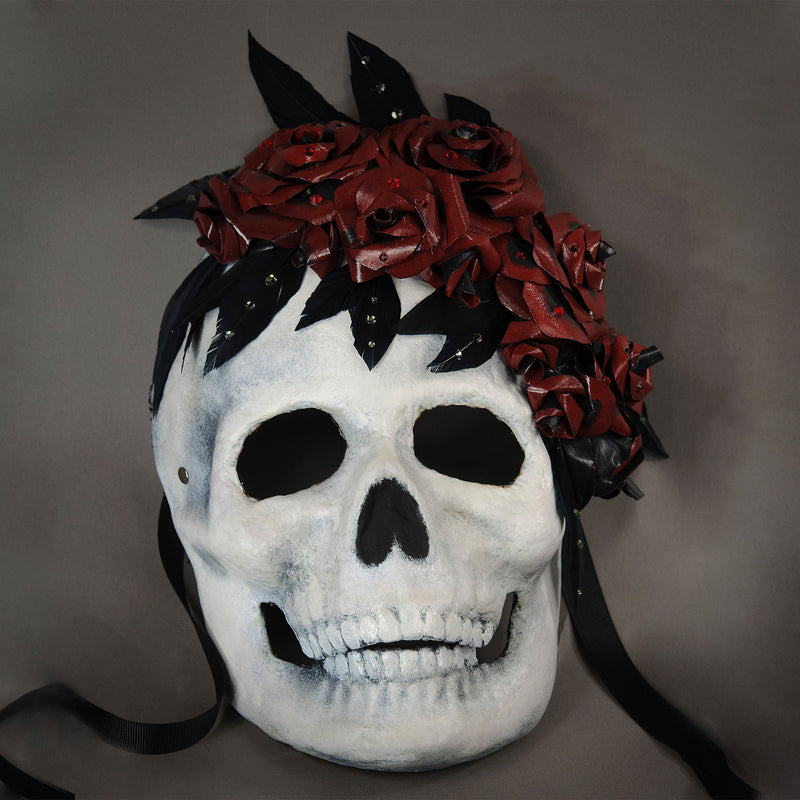 Perfect for Halloween or any dark themed masquerade, this skull mask is killer! The skull is framed with a bouquet of handmade lacquered paper roses with black feathered leaves, sprinkled with assorted Swarovski crystals.  Handmade in the USA using the traditional Venetian paper mache process. Lined with soft stretch velvet for comfort.